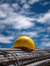 Hard Hat Resting on Stacked Rebar Under a Bright Blue Sky With Scattered Clouds During Daylight Hours on a Construction Royalty Free Stock Photo