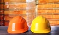 Hard hats on wooden surface near pallets with bricks Royalty Free Stock Photo