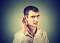 Hard of hearing man placing hand on ear asking to speak up Royalty Free Stock Photo