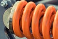 Hard orange spring made of steel. Part of big industrial or agricultural machine Royalty Free Stock Photo