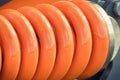 Hard orange spring made of steel. Part and detail of industrial or agricultural machine Royalty Free Stock Photo