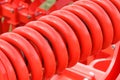 Hard red spring made of steel. Part and detail of industrial or agricultural machine Royalty Free Stock Photo