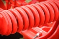 Hard red spring made of steel. Part and detail of industrial or agricultural machine Royalty Free Stock Photo