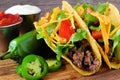 Hard shelled tacos with ground beef, lettuce, tomatoes, cheese close-up