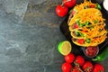 Hard shelled tacos with ground beef, vegetables and cheese, border on a dark background