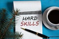 HARD SKILLS - words in a white notebook on the background of a cup of coffee and a spruce branch