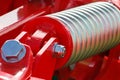 Hard spring made of steel. Part and detail of red industrial or agricultural machine Royalty Free Stock Photo