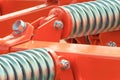 Hard spring made of steel. Part and detail of red industrial or agricultural machine Royalty Free Stock Photo