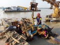 Hard structures of idol poluting the holy river Ganga after immersion ,corporation worker removing it by crane.