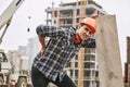 Hard work. Construction worker in protective helmet feeling back pain while working at construction site. Building Royalty Free Stock Photo