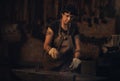 Hard work is always the way. a young woman hitting a hot metal rod with a hammer in a foundry. Royalty Free Stock Photo