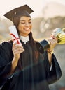 Hard work will always be rewarded. a student holding her diploma and trophy on graduation day. Royalty Free Stock Photo