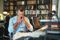 Hard work. Young exhausted bearded businessman covering his eyes and feeling stressed while sitting in modern office Royalty Free Stock Photo