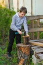 Hard-working boy chopping wood