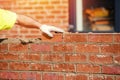 Hard working bricklayer lays bricks on cement mix on construction site. Fight housing crisis by building more affordable houses Royalty Free Stock Photo