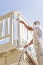 Hard Working House Painter Spray Painting A Deck of A Home Royalty Free Stock Photo