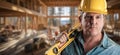 Hard Working Male Contractor at a Construction Site Wearing a Hard Hat and Work Gloves Holding His Level Royalty Free Stock Photo