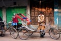 Hard working rickshaw waits for the passengers with his vintage bicycle cab on the street