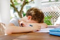 Hard-working sad school kid boy making homework during quarantine time from corona pandemic disease. Upset tired child Royalty Free Stock Photo