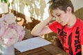 Hard-working sad school kid boy making homework during quarantine time from corona pandemic disease. Upset tired child Royalty Free Stock Photo