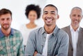 Hard works paid off with the right job. Portrait of smiling young man with colleagues in the background. Royalty Free Stock Photo