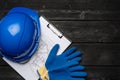 Hardhat, gloves and blueprints of a builder Royalty Free Stock Photo