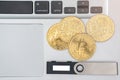 Hardware cryptocurrency wallet with golden Bitcoin BTC on computer. Safe storage for crypto