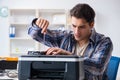 The hardware repairman repairing broken printer fax machine