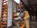 Woodinville, WA USA - circa March 2021: Hardware store worker cutting PVC pipe with a buzz saw in the lumber yard at a McLendon