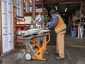Woodinville, WA USA - circa March 2021: Hardware store worker cutting PVC pipe with a buzz saw in the lumber yard at a McLendon