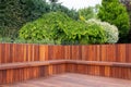 Hardwood timber deck, bench and cladding wood structure with greenery garden view, brown and green natural elements