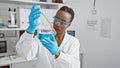 Hardworking and beautiful african american woman scientist analyzing test tube in a high-tech laboratory