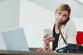 Hardworking businesswoman multi tasking with phone and laptop