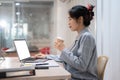 A hardworking businesswoman sipping coffee while working on her project on her laptop in her office Royalty Free Stock Photo