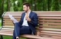 Hardworking CEO looking through documents while having lunch on bench at park