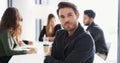 The hardworking are deserving of success. Portrait of a young businessman sitting in an office with his colleagues in