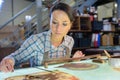 Hardworking female carpenter using abrasive paper