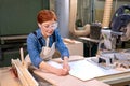 Hardworking female carpenter working as wood designer in small carpentry workshop