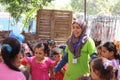 Hardworking Female teacher playing with little kids in playground