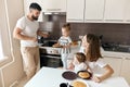 Hardworking girl treating her parents and little sister with yummy pancakes