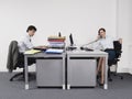 Hardworking Man And Relaxed Woman in office Royalty Free Stock Photo