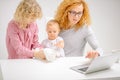 Hardworking mother using the laptop while her children playing with fluffy kitten Royalty Free Stock Photo