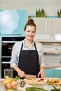 Hardworking wife is looking at the camera while cooking dinner for guests