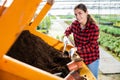 Hardworking young farmer woman fills a flower pot with nutritious soil