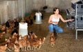 Hardworking young girl collects eggs in a chicken coop