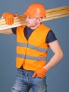 Hardy labourer concept. Carpenter, woodworker, labourer, builder on busy face carries wooden beams on shoulder. Man in