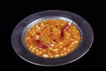 Haricot bean. Dried beans,white beans in tomato sauce in a copper bowl dry chili pepper on the plate Royalty Free Stock Photo