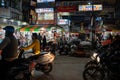 Motorbike drivers navigate their vehicles through the crowded night market