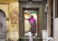 HARIDWAR, INDIA - MARCH 23, 2014: indian woman wearing colourful sari In the doorway.