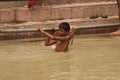 Boy is swimming in the Ganga  river in India. Royalty Free Stock Photo
